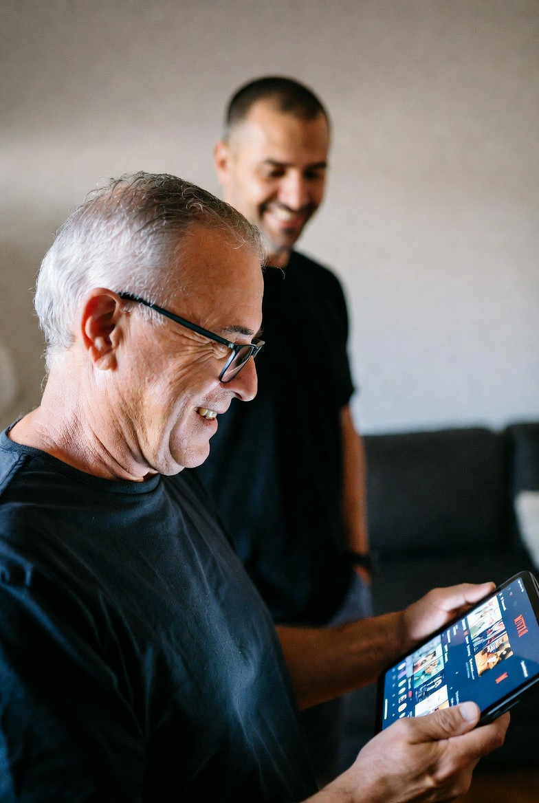 Senior smiling at tablet